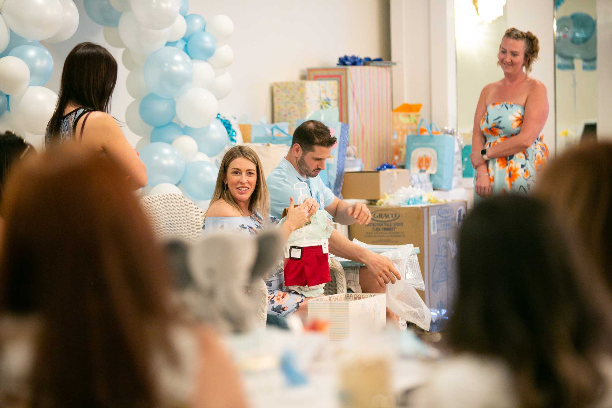 A couple opening gifts at their baby shower at Danversport