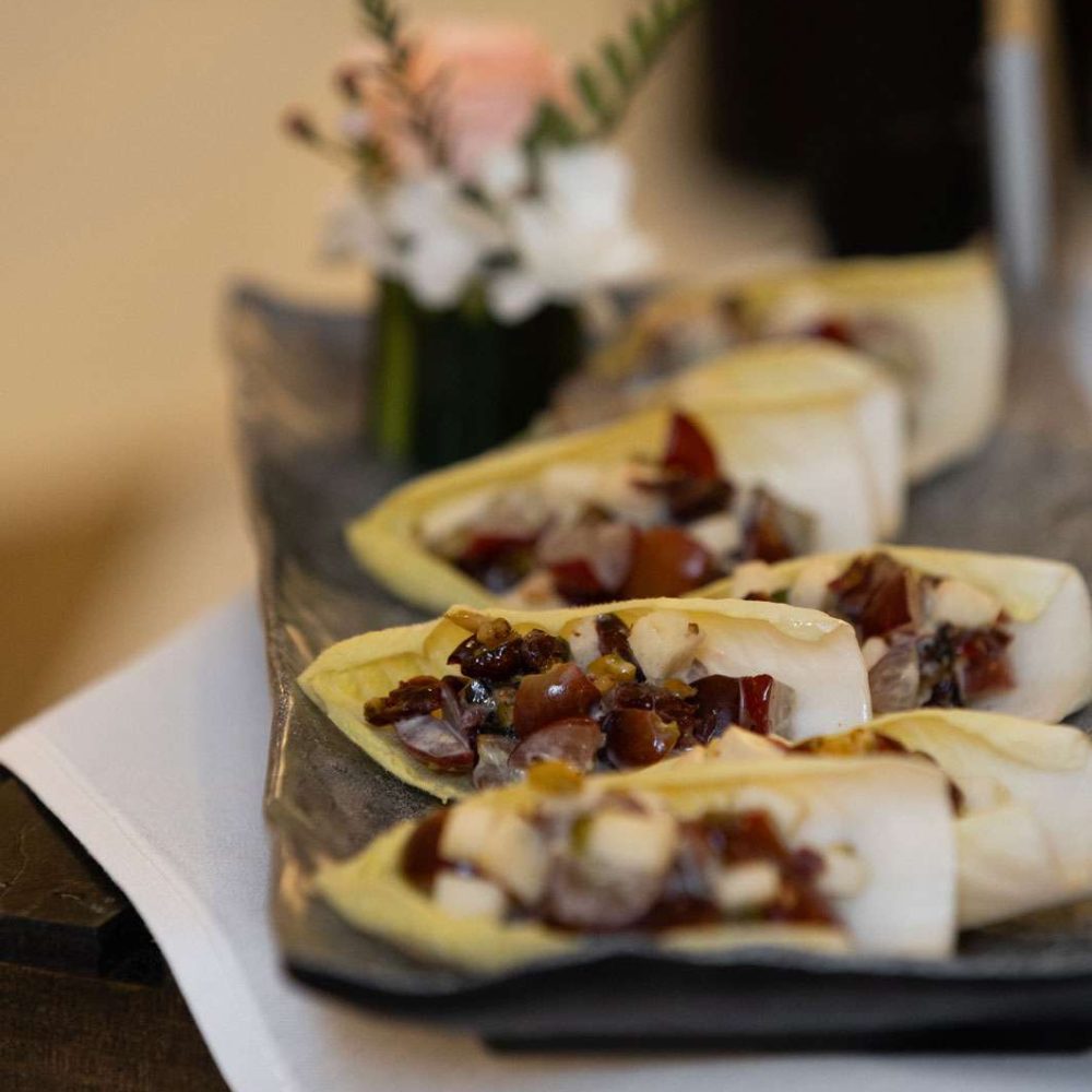 Endive Wrap filled with chopped apples, grapes, pistachios, almonds, and cranberry cheese