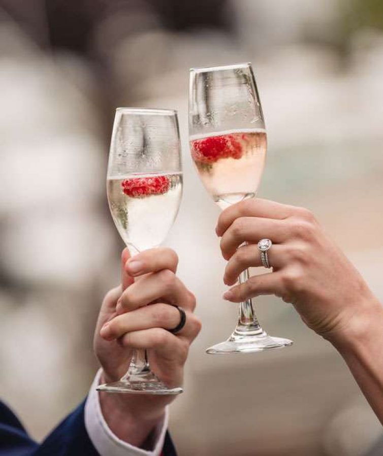 A bride and groom toast with champagne.