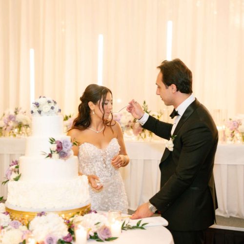 A groom feeds his bride cake after the cake cutting